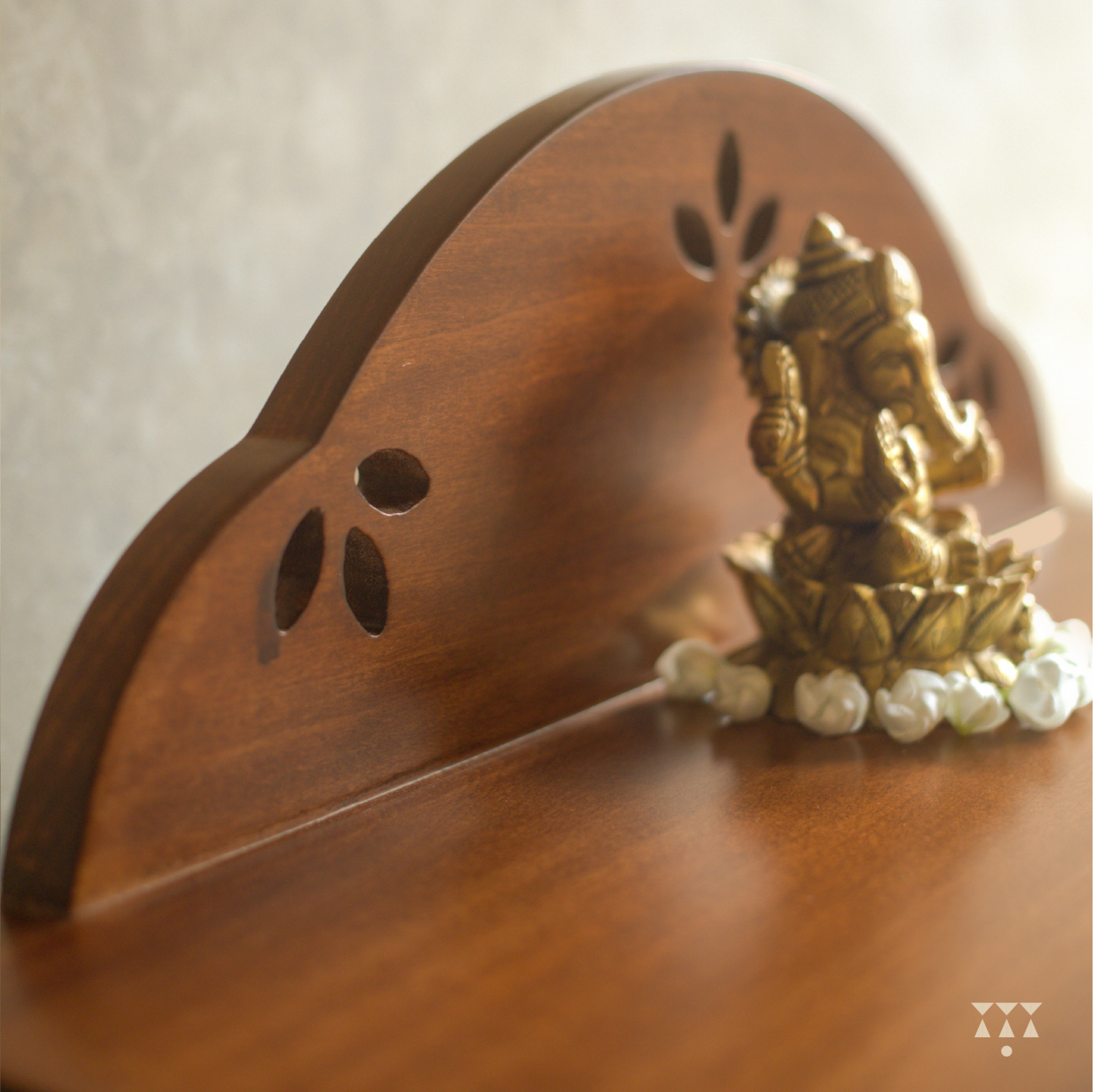 Close up of a wooden pooja platform with lord ganesh statue placed on it.