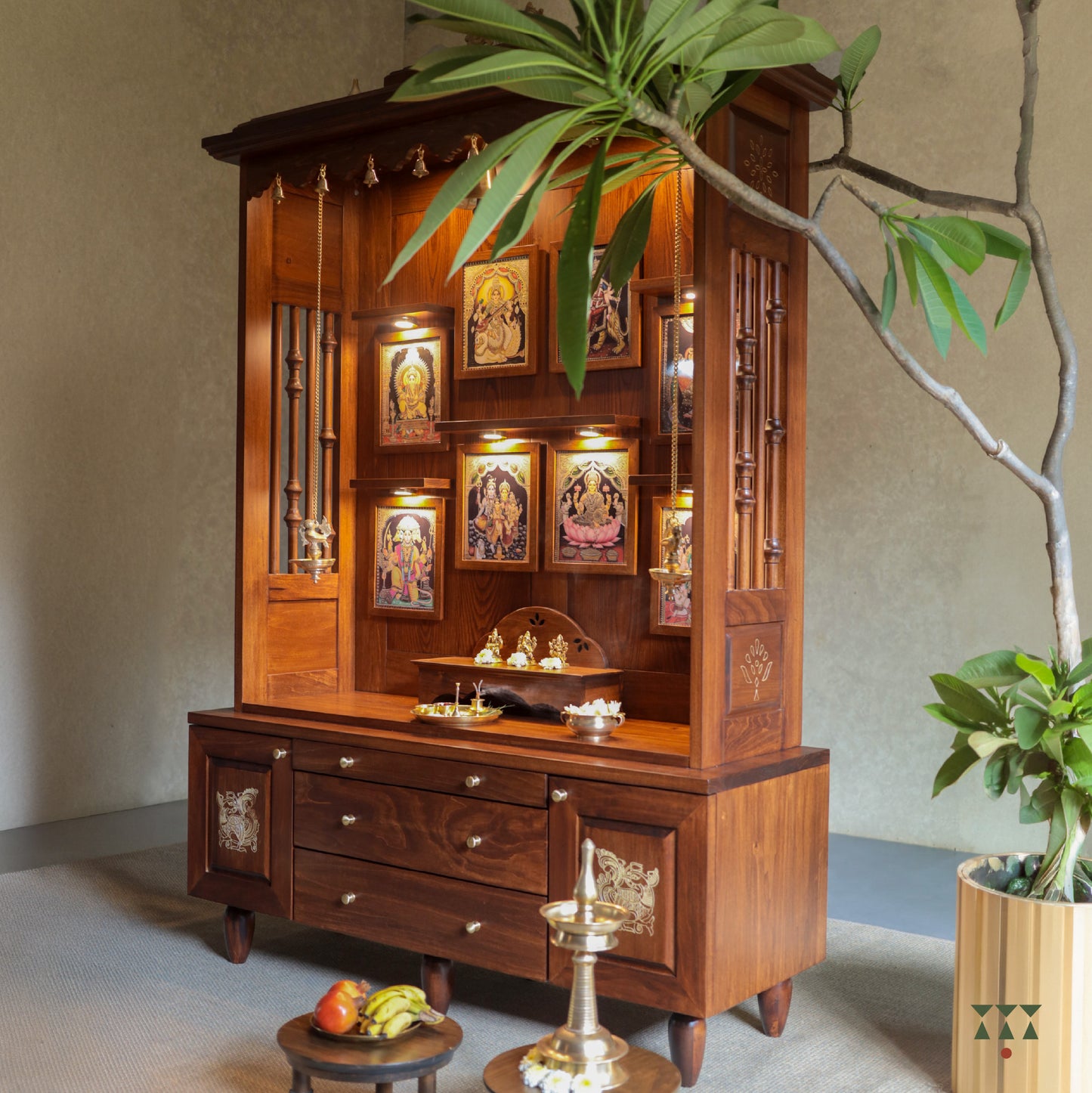Side view of an open wooden mandir with tanjore paintings and pooja accessories