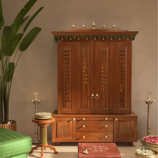 A solid wood mandir with pure brass bells, Tanjore art prints, cutwork designs and storage, tinted in an almond brown color